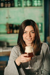 Bella donna sorridente beve la birra