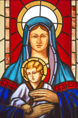Stained glass window with stained glass depicting the Virgin Mary and baby Jesus - obrazy, fototapety, plakaty