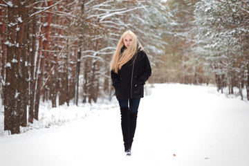 girl in the winter woods on a snowy road