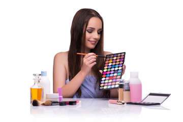 Woman doing makeup isolated on white