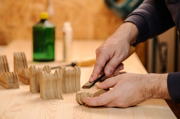 Obraz na płótnie Canvas Carpenter hands cutting wood with chisel