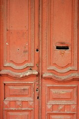 Vintage wooden door painted red with letterbox hole