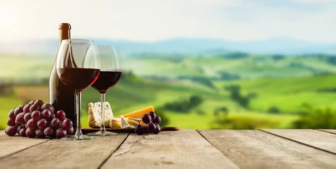 Fond de hotte en verre imprimé Vignoble Vin rouge servi sur des planches de bois, vignoble en arrière-plan