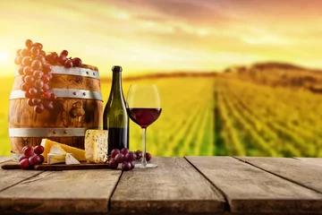 Deurstickers Rode wijn geserveerd op houten planken, wijngaard op achtergrond © Jag_cz
