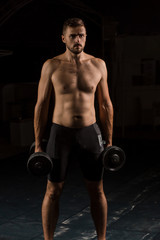 Fototapeta na wymiar Muscular bodybuilder handsome man doing exercises in outdoor gym naked torso