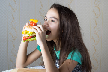 11 year old girl eating a hamburger, side view