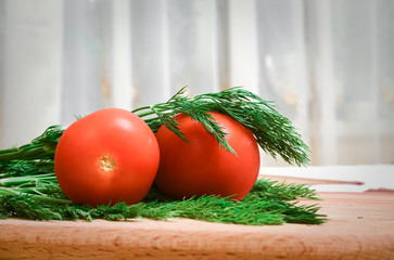 fresh tomatoes and greens on a wooden table