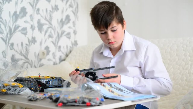 Teen boy collects constructor in room