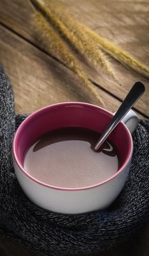 Hot chocolate and scarf on wooden table