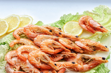 Close-up of shrimp on lettuce leaves with seasoning and lemon on