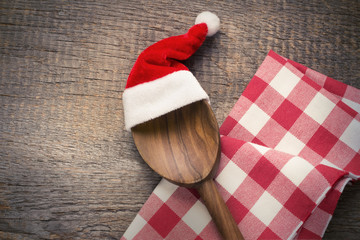Kochlöffel mit Weihnachtsmütze und Küchentuch