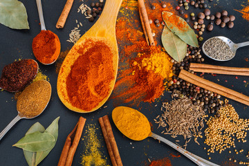 Various spices spoons on stone table.