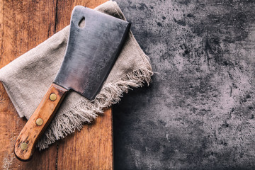 Butcher. Vintage butcher meat cleavers with cloth towel on dark concrete or wooden kitchen  board.