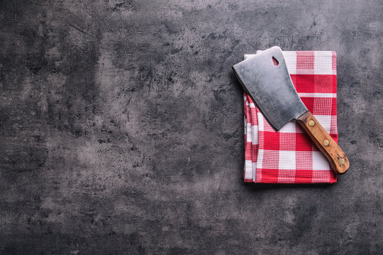 Butcher. Vintage butcher meat cleavers with cloth towel on dark concrete or wooden kitchen  board.