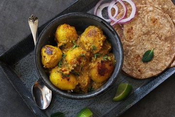 Dum Aloo - Indian dish using baby potatoes slow cooked in tomato onion spiced gravy, selective focus