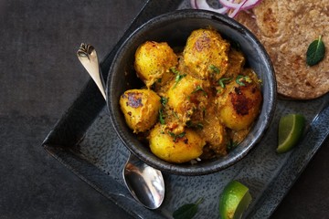 Dum Aloo - Indian dish using baby potatoes slow cooked in tomato onion spiced gravy, selective focus