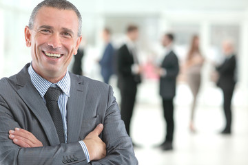 Happy mature business man looking at camera with satisfaction at office