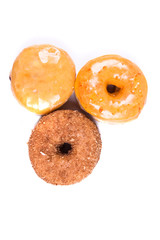 Assorted glazed and frosted donuts isolated on a white background