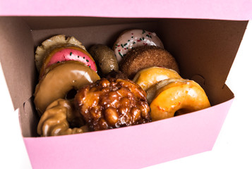 An assorted dozen donuts in a box isolated on a white background