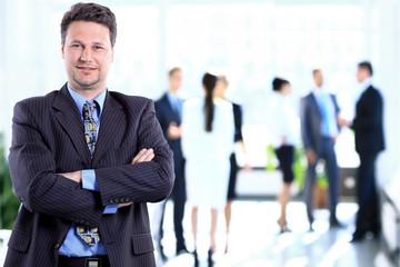 Fototapeta premium Happy mature business man looking at camera with satisfaction at office
