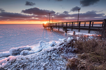 Winter landscape on Hel Peninsula. Wooden pier and frozen Baltic sea. Poland, Europe. - obrazy, fototapety, plakaty