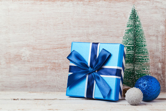 Christmas background with blue gift box and pine tree