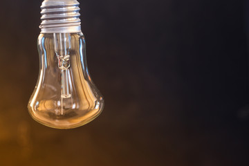 Obraz na płótnie Canvas Light bulb on a dark blurred background