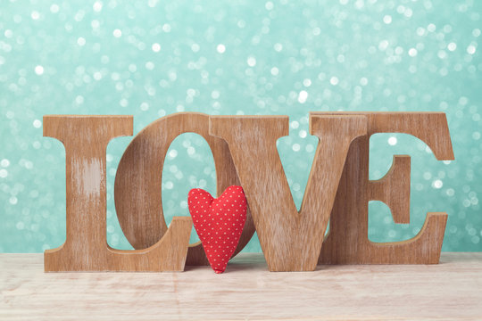 Valentine's day concept with wooden letters love and heart shape over mint background