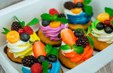 Colorful cupcakes in a gift box with a bow.