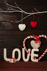 Valentine's day concept. Letters LOVE and hearts made of yarn on a dark wooden background.