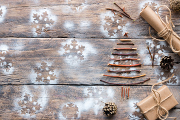 Christmas tree made of twigs, gifts and cones on the wooden background with space for text