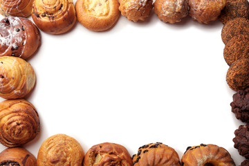 Frame of assorted fresh pastries on white background