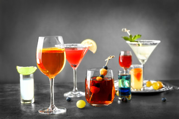 Different cocktails with sweet berries on gray table