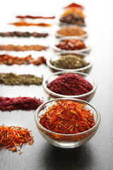 Various spices in glass bowls on grey table