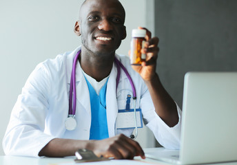 Close-up male doctor giving jar of pills to patient.