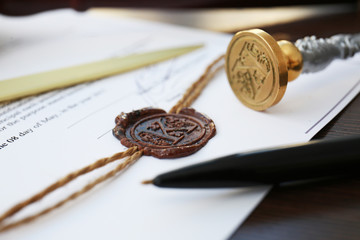 Old notarial wax stamp on document and pen, closeup
