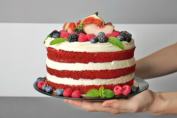Woman holding tasty cake with berries, closeup