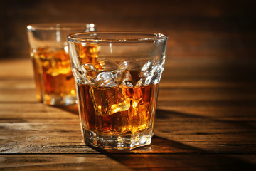 Glasses of whisky on wooden table closeup