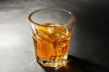 Glass of whisky on grey textured table closeup
