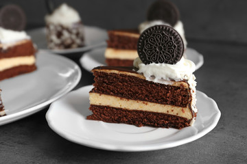 Plates with pieces of tasty chocolate cake on dark table