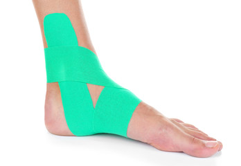 Female foot with physio tape on white background