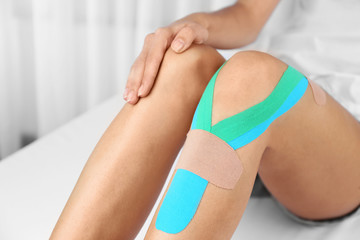 Female knee with physio tape, closeup
