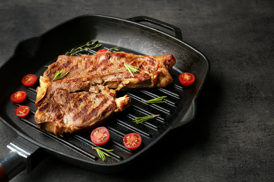 Composition of tasty steak, cherry tomatoes and herbs on pan