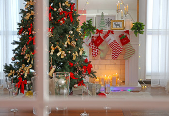 View on Christmas decoration of fireplace in living room through window