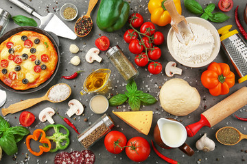 Delicious pizza with ingredients and spices on table