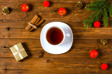 Obraz na płótnie Canvas Christmas concept: decoration and a cup of tea on a wooden backg
