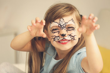 Obraz premium Portrait of funny girl with face painting on blurred background