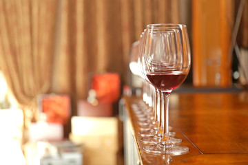 Row of glasses with red wine on bar counter