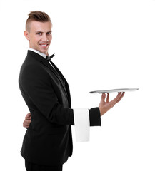 Handsome young waiter with tray on white background