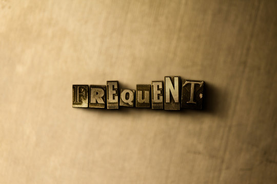 FREQUENT - close-up of grungy vintage typeset word on metal backdrop. Royalty free stock - 3D rendered stock image.  Can be used for online banner ads and direct mail.